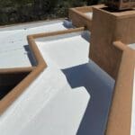 Flat rooftop with fresh white coating, highlighting detailed repair work by a roofing maintenance company.